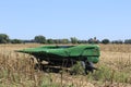 John Deere Combine Header sitting in a farm field with corn stubble and blue sky out in the country in Kansas.