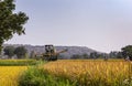 John Deere pick thresher on the move in field, Hunumanahalli, Karnataka, India