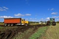 John Deere 9620 T tractor pulling truck in muddy field