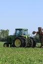 John Deere Tractor in a green Corn field out in the country with blue sky Royalty Free Stock Photo