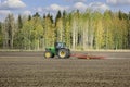 John Deere Tractor and Harrow in Field