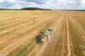 John Deere Tractor with John Deere L1534 Square Baler making Hay Bales in an agricultural field. Farm Hay Bale Tractor Baler. High Royalty Free Stock Photo