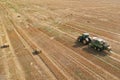 John Deere Tractor with John Deere L1534 Square Baler making Hay Bales in an agricultural field. Farm Hay Bale Tractor Baler. High Royalty Free Stock Photo