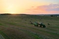 John Deere Tractor 6715R with John Deere V461R round baler making Hay Bales in an agricultural field. Farm Round Hay Bale Tractor Royalty Free Stock Photo