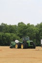 John Deere Tractor with a Great plains drill on the back for planting sitting in a wheat stubble farm field in Kansas.