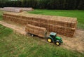 John Deere tractor with straw hay trailer the transporting round bales.  Storage hay at farm. Hay Forage feed for beef and dairy Royalty Free Stock Photo