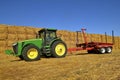 John Deere tractor and trailer by bale stack