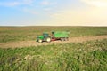 John Deere Tractor with trailer working in a potato field. Agricultural tractor at field. Seasonal harvesting of potatoes from the Royalty Free Stock Photo