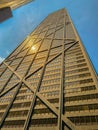 John Hancock side against blue sky and clouds.