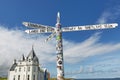 Britains lands end sign at john o`groats in scotland with blue skies and ocean and grass in background. Has many stickers on post