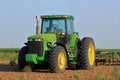 Johndeere Tractor in a Kansas farm field with blue sky.