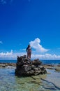 JOHNNY CAY, COLOMBIA - OCTOBER 21, 2017: Unidentified woman enjoying the beautiful sunny day over a rock in the coast of