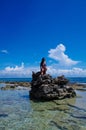 JOHNNY CAY, COLOMBIA - OCTOBER 21, 2017: Unidentified woman enjoying the beautiful sunny day over a rock in the coast of