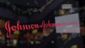 Johnson and Johnson logo on the glass against blurred business center. Editorial 3D rendering