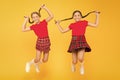 Join celebration. Cheerful friends schoolgirls jumping yellow background. Celebrate holiday. Scottish holiday. Kids girl