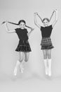 Join celebration. School uniform. Scottish style. Cheerful friends schoolgirls jumping yellow background. Celebrate