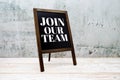 Join Our Team word on blackboard stand on wooden background Royalty Free Stock Photo