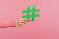 Join popular blog! Closeup of female hand holding green hashtag sign, sharing tagged message, recommending follow trends