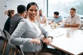 Join us. Cropped portrait of an attractive young businesswoman attending a meeting in the boardroom with her colleagues Royalty Free Stock Photo