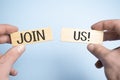 Join us sign on wooden cubes on blue background Royalty Free Stock Photo