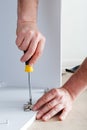 Joiner collects furniture using hand tools screwdriver. Furniture assembly using screwdriver. Moving, home improvement, furniture Royalty Free Stock Photo