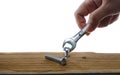 Joiner hand with a wrench screwing a furniture screw into a wooden plank at white background, The effort wrong of tools as a fail