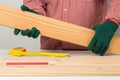 joiner measuring a wooden plank with tape measure yellow on the work-table for construction, carpenter Use tool checking accuracy