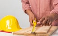 Joiner measuring a wooden plank with tape measure yellow on the work-table for construction, carpenter Use tool checking accuracy Royalty Free Stock Photo