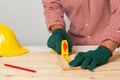 joiner measuring a wooden plank with tape measure yellow on the work-table for construction, carpenter Use tool checking accuracy