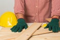 Joiner measuring a wooden plank with tape measure yellow on the work-table for construction