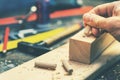 Joiner putting dowel pin into a piece of wood