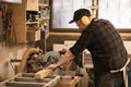 Joiner worker, businessman in protective apron and headphones use modern grinder machine to process cutting wood boards Royalty Free Stock Photo