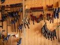 Joinery clamps of different sizes hang on the wall Royalty Free Stock Photo