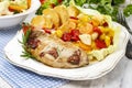 Joint of pork with baked potatoes and fresh vegetables Royalty Free Stock Photo