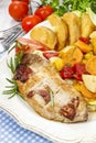 Joint of pork with baked potatoes and fresh vegetables Royalty Free Stock Photo