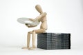 Jointed doll sitting cd stack Royalty Free Stock Photo