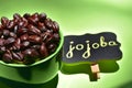 Jojoba seeds in a green bowl