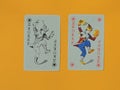 The joker playing cards are red and black on a yellow background. Royalty Free Stock Photo