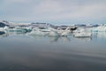 Jokulsarlon glacier lagoon bay with blue icebergs floating on still water with reflections, Iceland Royalty Free Stock Photo