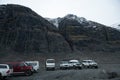 : Off road cars of ice cave tours parked near scenic mountain