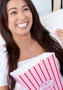 Jolly asian woman eating pop corn