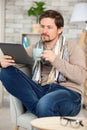 jolly bearded guy having rest using computer gadget indoor