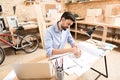 Jolly bearded woodworker drawing lines on timber item at table