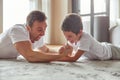 Happy man enjoying active time with son indoors