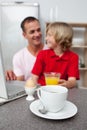 Jolly father and his son having breakfast