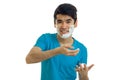 Jolly nice guy with black hair and blue t-shirt laughs with foam on his face