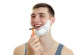 Jolly nice guy with foam beard holds in his hand shaving machine and laughs is isolated on a white background