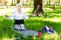 Jolly old lady making relaxation exercises in forest Royalty Free Stock Photo