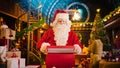 Jolly Santa Claus Works in His Studio Workshop, Wrapping and Packing Christmas Gifts for all the Royalty Free Stock Photo