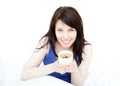 Jolly woman drinking a coffee sitting on her bed Royalty Free Stock Photo